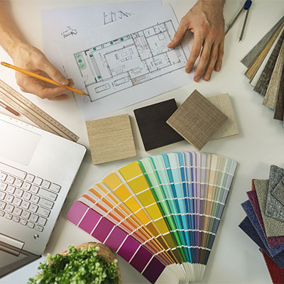 Professional design consultation showing material samples and blueprints