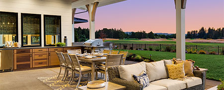 Evening photo of an illuminated outdoor kitchen setup ready for a BBQ