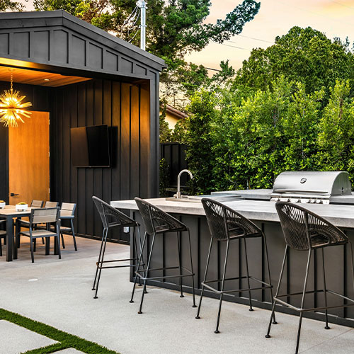 Photo of an illuminated outdoor kitchen setup ready for a BBQ